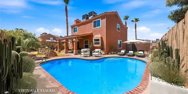 Image 2: An inviting backyard oasis features a curved swimm
