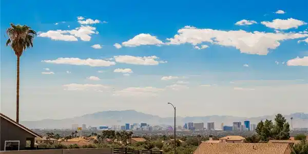 Image 4: Distant city skyline and mountain views create a p
