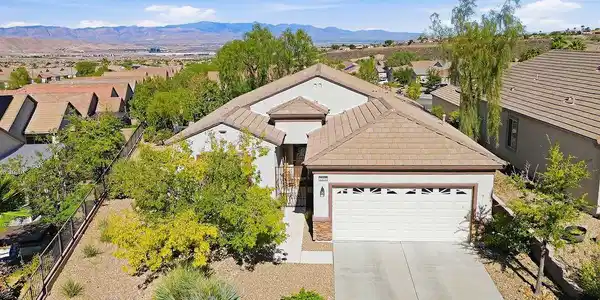 Image 2: An inviting exterior features a concrete driveway,
