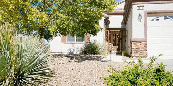 Image 3: Desert landscaping and stone accents frame the wel