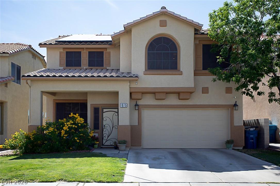 Image 1: A cream-colored stucco exterior with a tiled roof