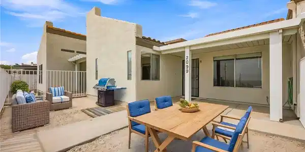 Image 3: An inviting outdoor patio features concrete walkwa