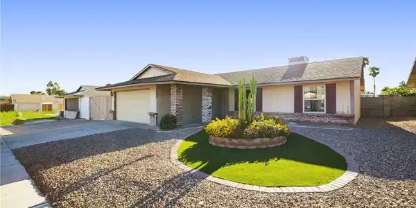 Image 3: Neat desert landscaping and a brick-accented exter