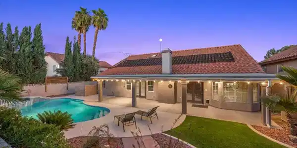 Image 2: A sparkling pool, expansive covered patio, and mat