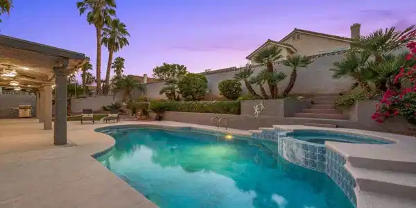 Image 3: A sparkling pool and spa, lush landscaping, and ge