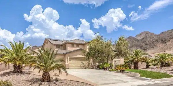 Image 3: Palm trees and desert landscaping frame this two-s
