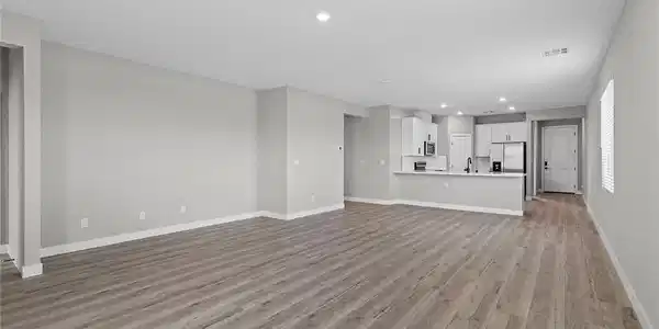 Image 2: Smooth wood-look flooring anchors a modern open la