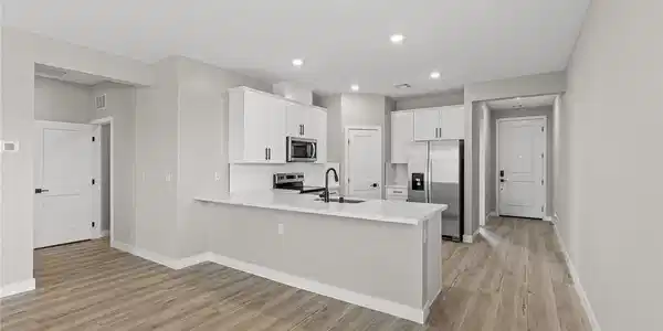 Image 3: Smooth wood-look flooring anchors this modern kitc