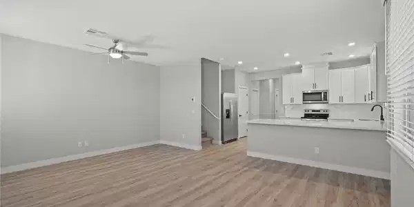 Image 3: Clean lines and warm wood floors define this open