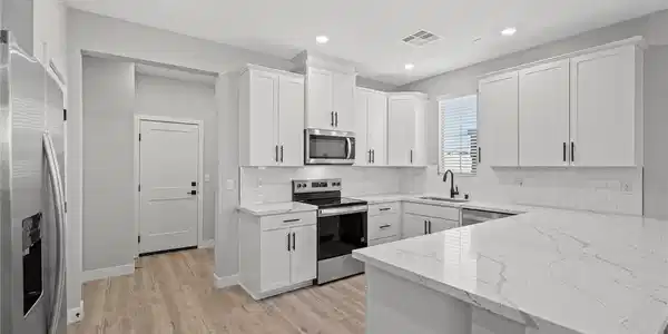 Image 4: Shaker cabinets and stone countertops with waterfa