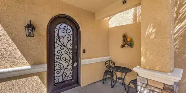 Image 4: An arched entry door with ornate ironwork welcomes