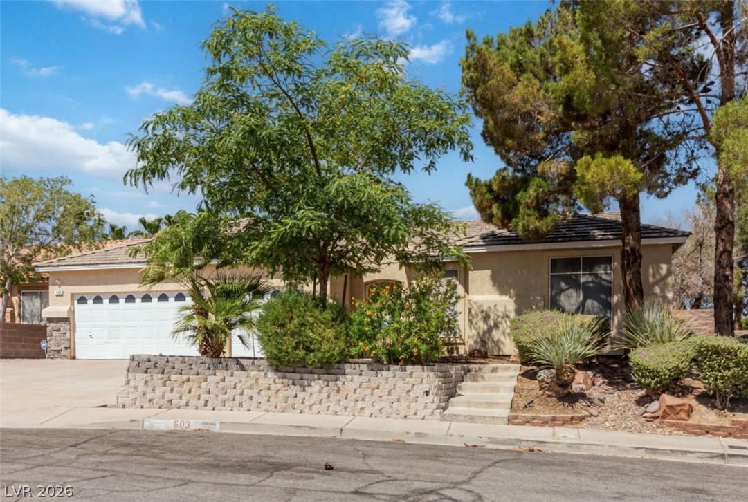 Image 2: A well-maintained stucco home with a double garage