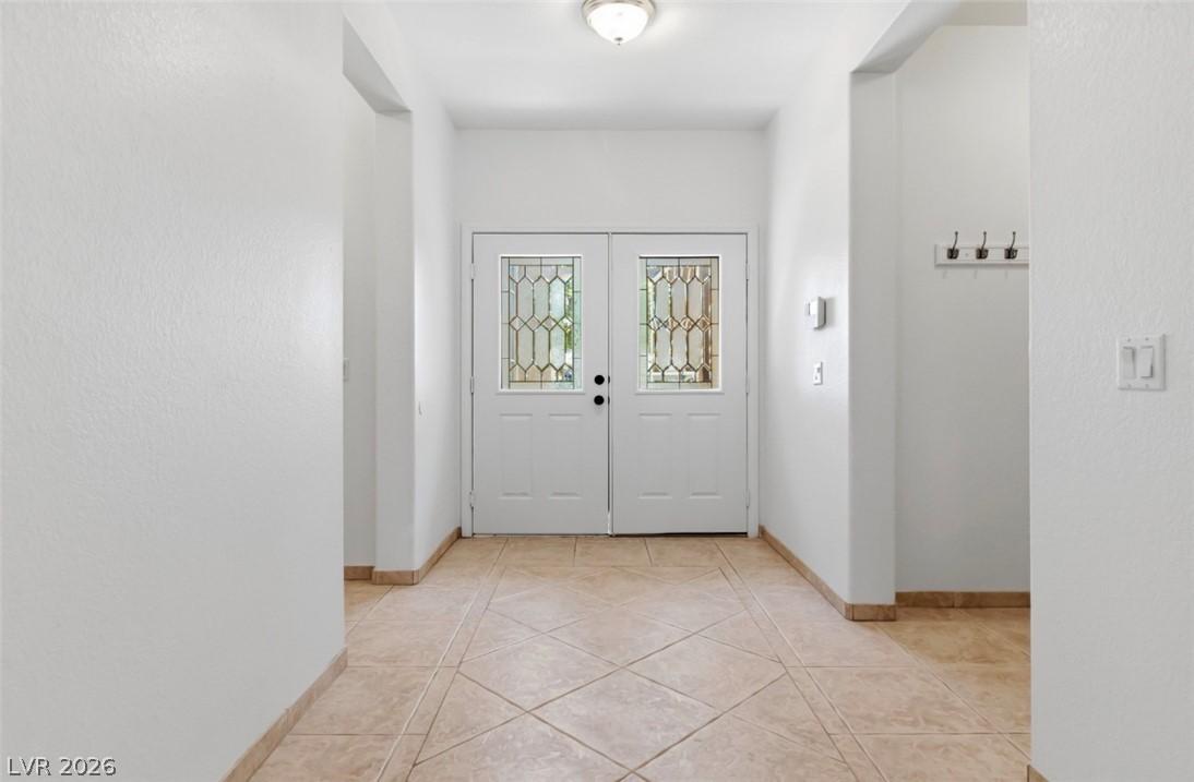 Image 3: A welcoming entryway with double doors featuring d