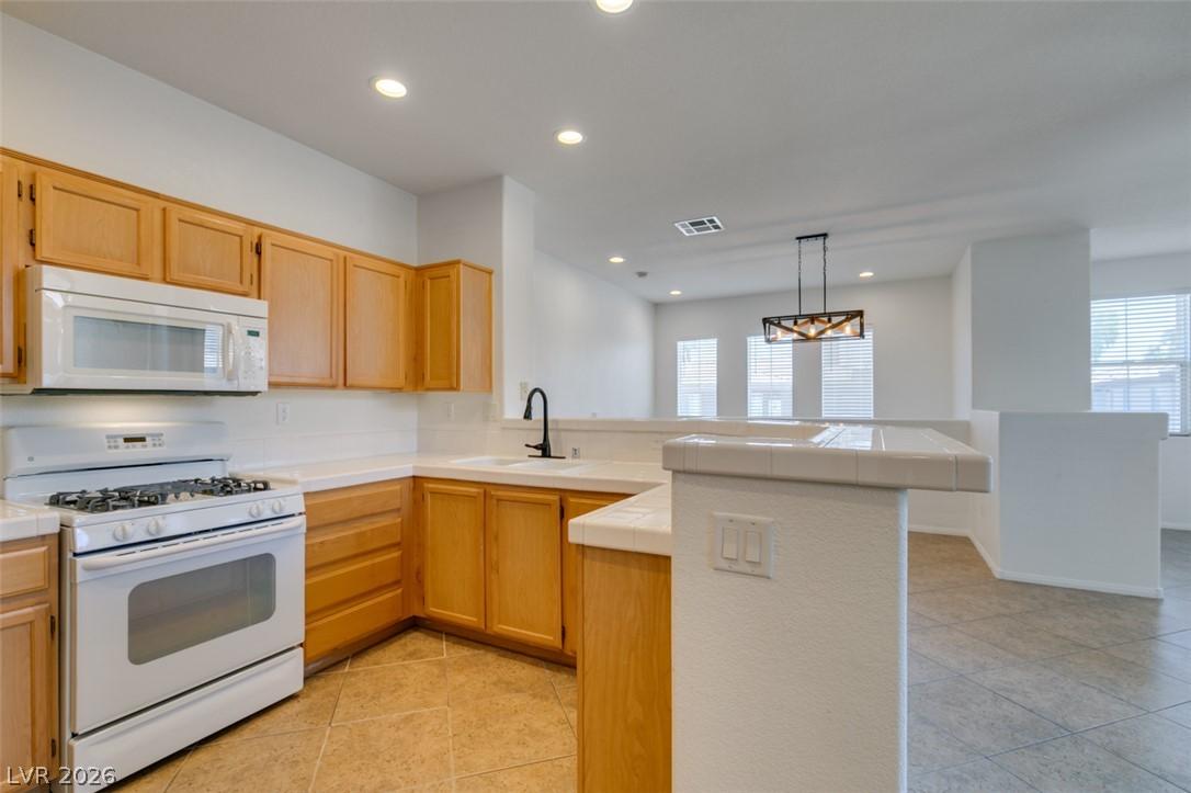 Image 3: A well-lit kitchen with natural wood cabinetry off