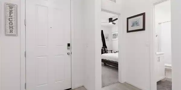 Image 2: Upon entry, discover light-hued flooring leading t