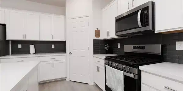 Image 4: Modern kitchen with sleek cabinetry, a gas range,