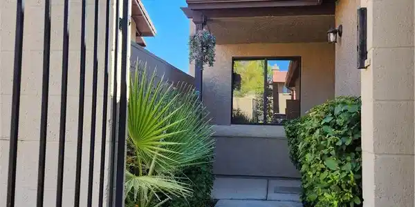 Image 3: A gated entry path lined with landscaping leads to