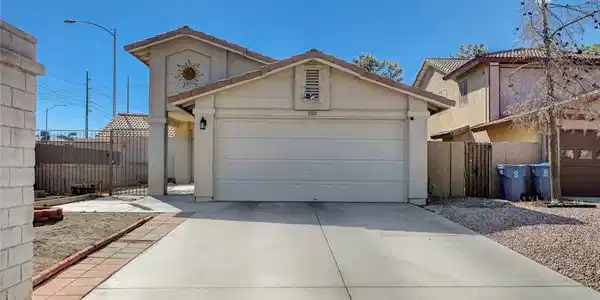 Image 2: A wide concrete driveway leads to an attached gara