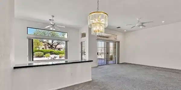Image 4: A spacious carpeted living area features glass sli