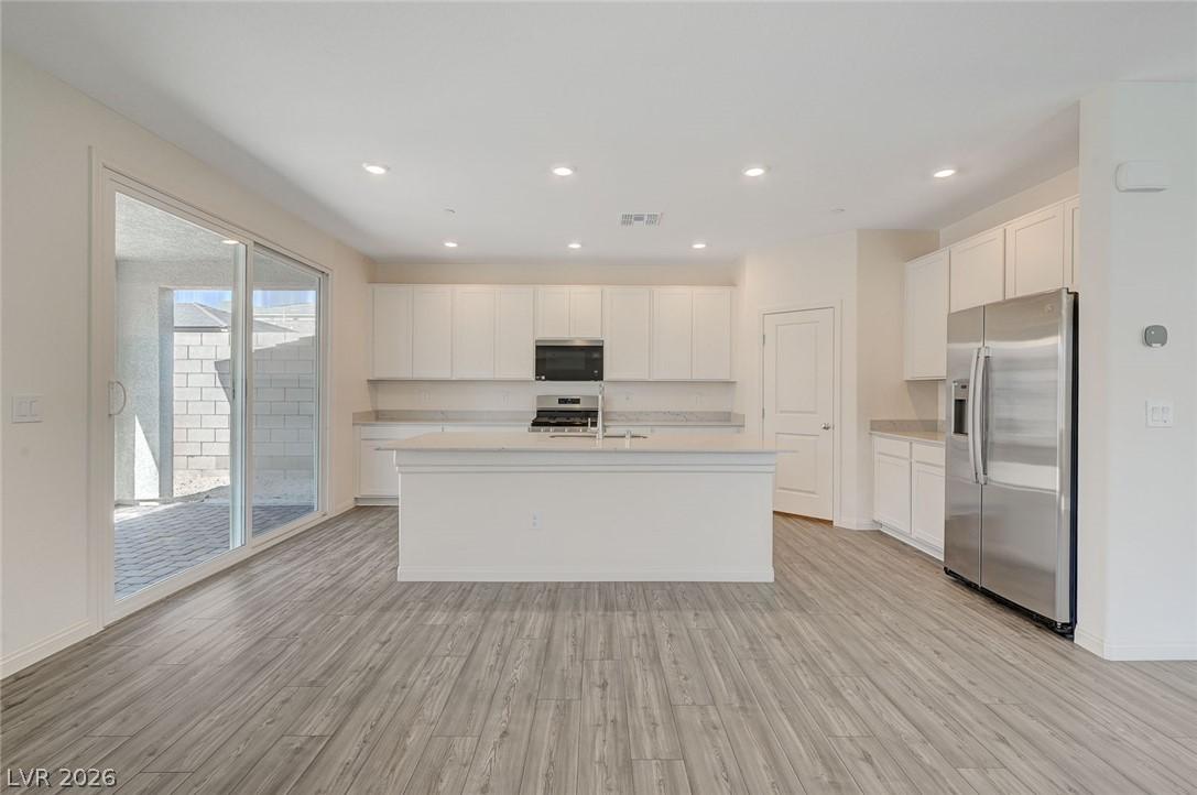 Image 2: A well-lit, open-concept kitchen and living area w