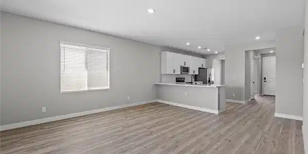 Image 3: Gleaming wood-look floors anchor this airy, open-c