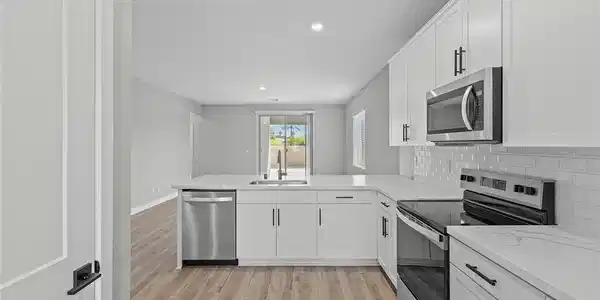 Image 4: Gleaming stone countertops and modern cabinetry li