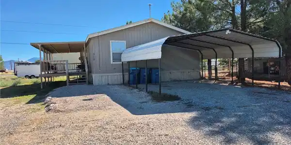Image 3: A spacious covered carport and wooden front porch