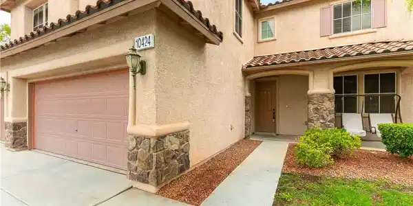 Image 2: Stone-accented stucco walls and a tiled roofline e