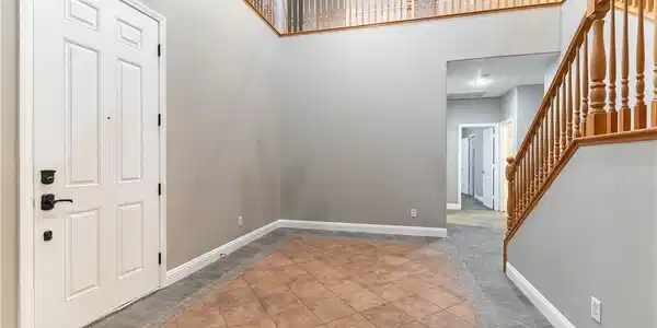 Image 3: An airy two-story foyer greets visitors with decor