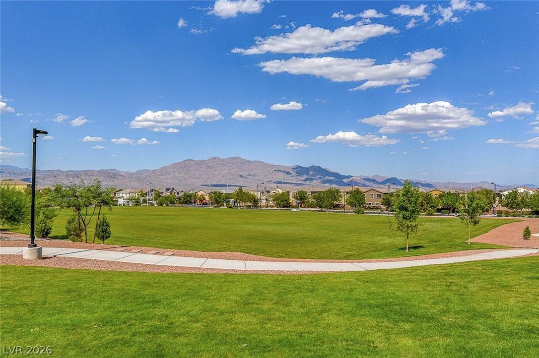 Image 2: Green open space against a mountain backdrop provi