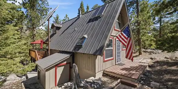 Image 2: Perched among towering pines, this A-frame cabin o