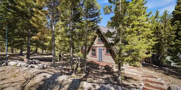 Image 3: An inviting A-frame dwelling nestled among towerin