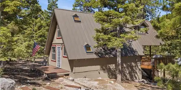 Image 4: Nestled among towering pines, this A-frame cabin f