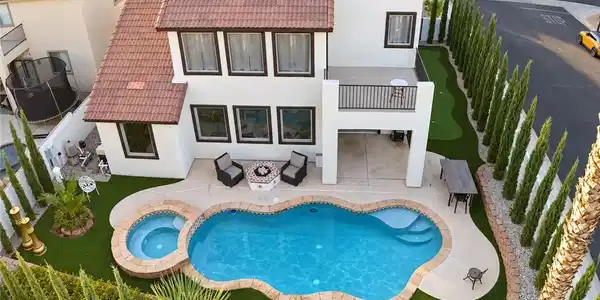 Image 2: An inviting backyard oasis showcases a freeform sw