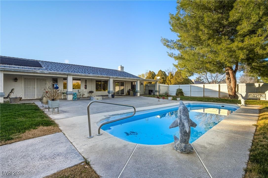 Image 1: View of pool featuring a patio and a fenced backya