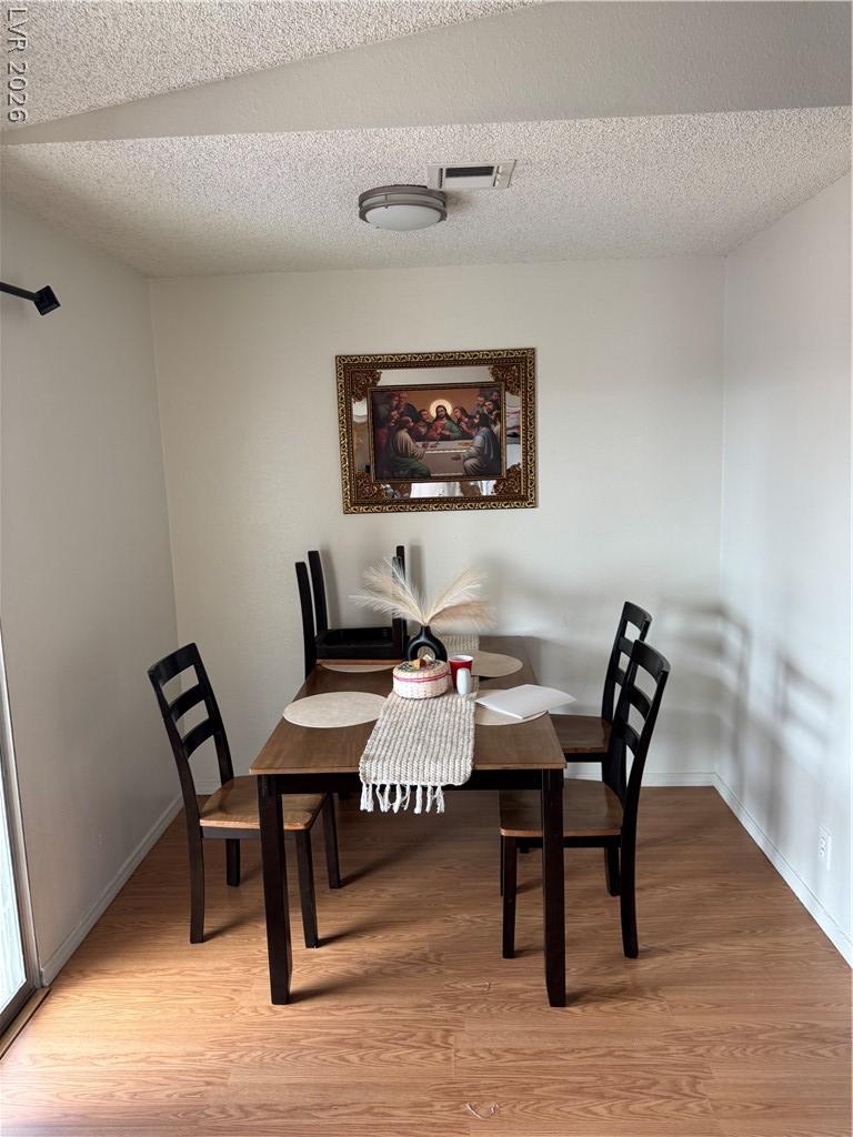 Image 4: Warm wood flooring defines a versatile dining area