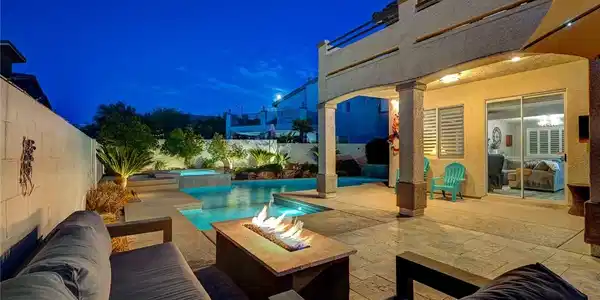 Image 2: A stone patio and a gas fire pit overlook a heated