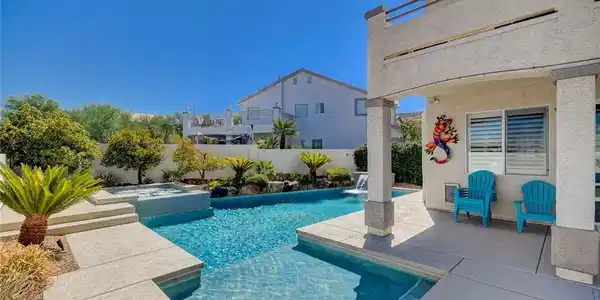 Image 3: An inviting backyard oasis features a sparkling sw