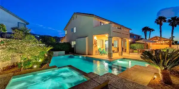 Image 4: An inviting backyard oasis features a shimmering p