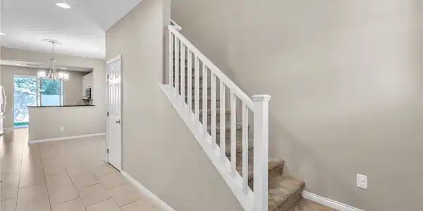 Image 3: Carpeted stairs with a crisp white railing accent
