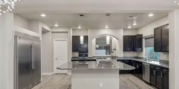 Image 4: Dark cabinetry and granite countertops frame a spa