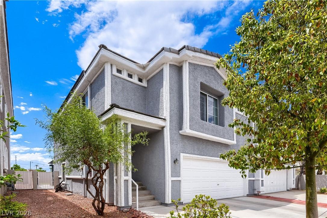 Image 1: A striking gray stucco exterior with white trim of
