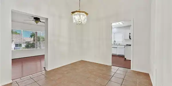 Image 4: A well-lit dining area features a graceful chandel