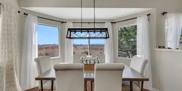Image 2: Rich hardwood flooring anchors this dining space f