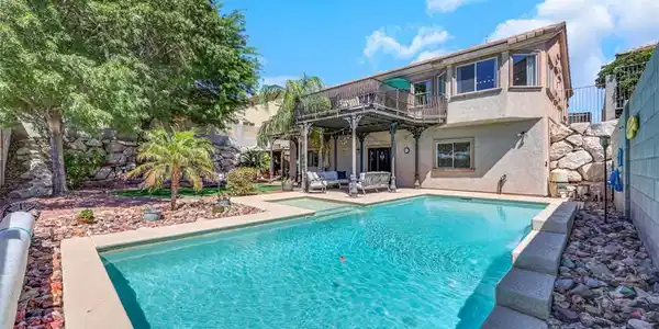 Image 3: An inviting backyard oasis features a shimmering s