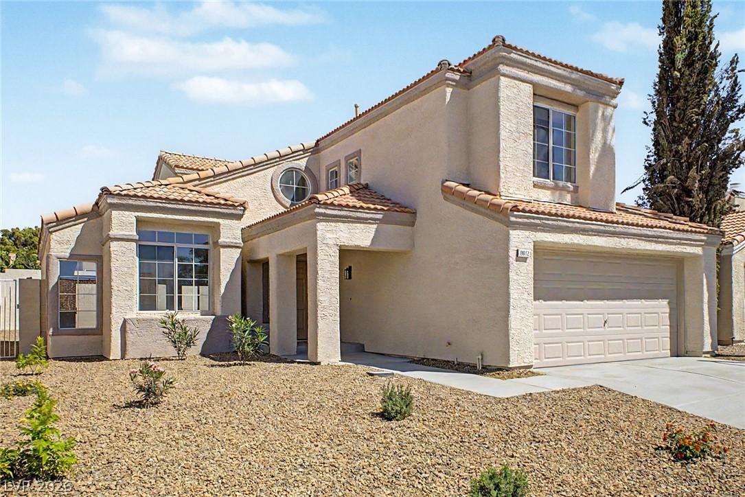 Image 2: A charming stucco home with a terracotta tile roof