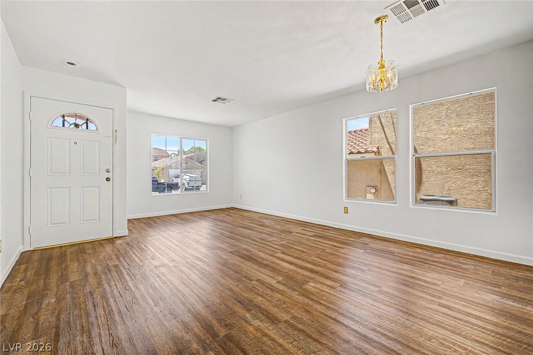 Image 3: Rich hardwood floors welcome you into this invitin