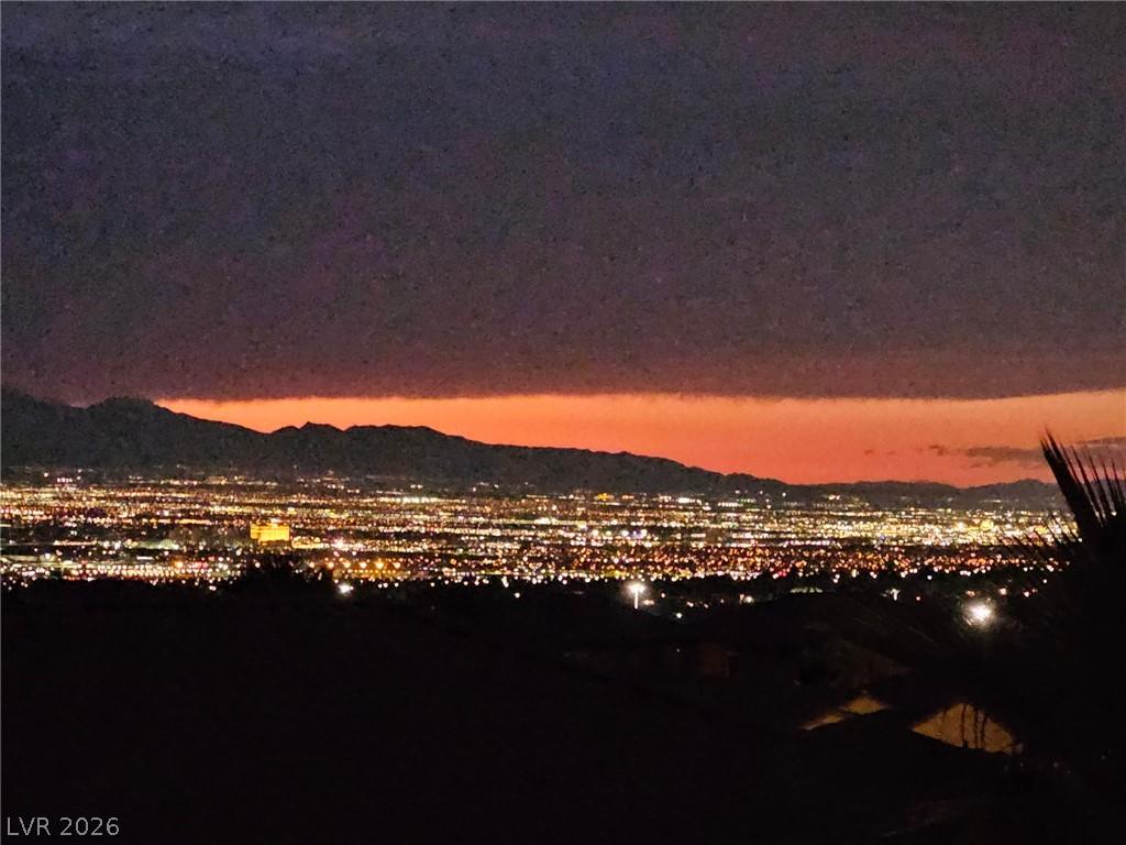 Image 2: City lights sparkle against a vivid sunset, framed
