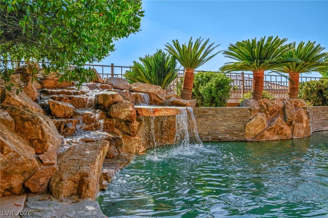 Image 3: A rock waterfall cascades into a refreshing privat