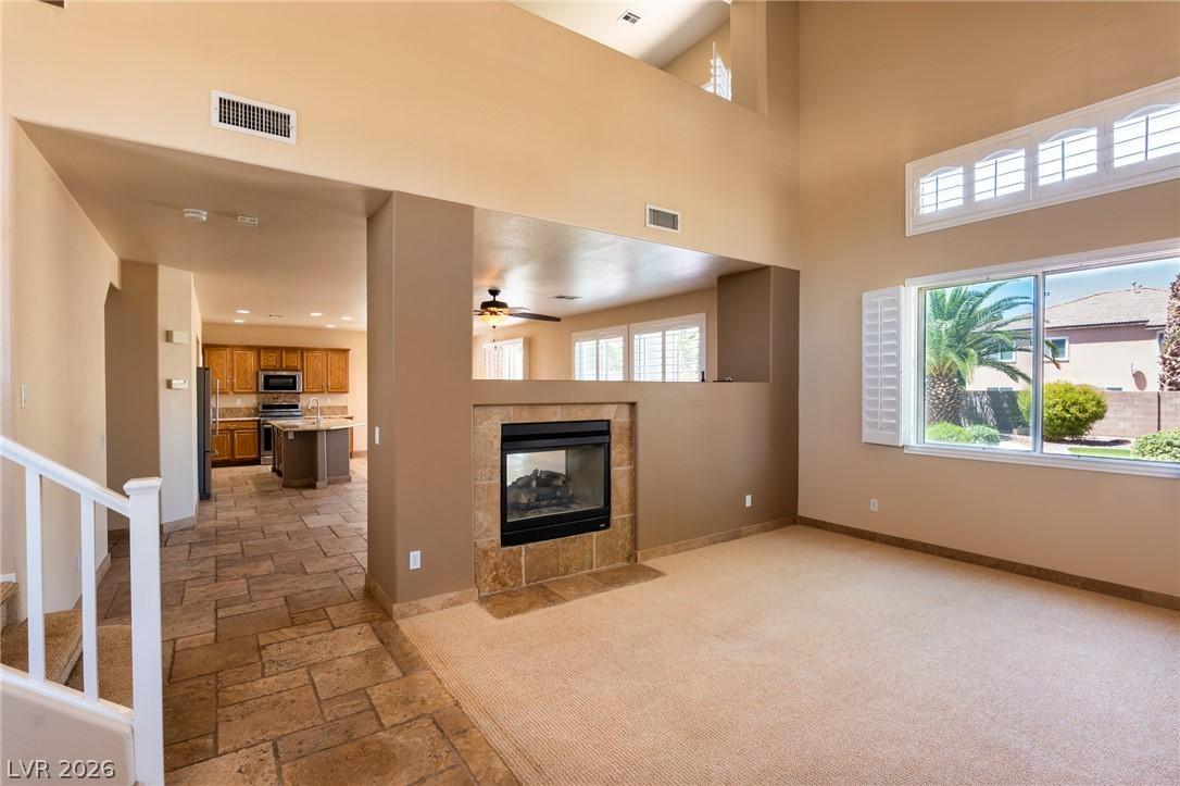 Image 3: Soaring ceilings, a cozy fireplace, and an open vi